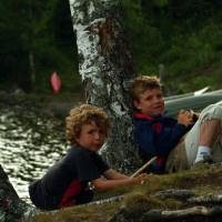 2 kinderen in het bos tegen een boom